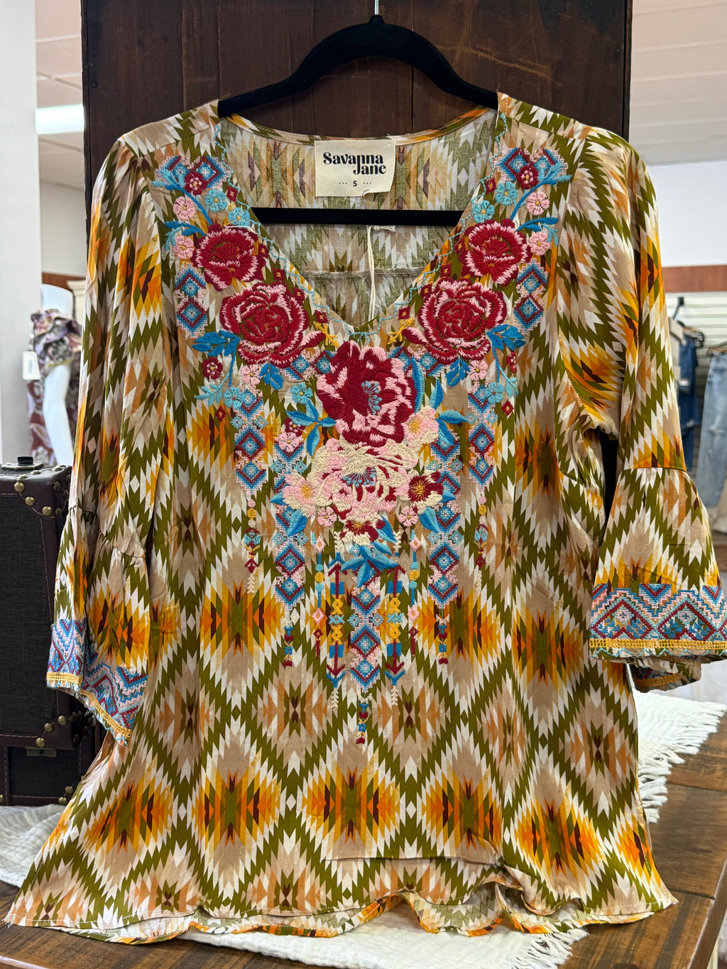 Colorful patterned fabric with floral and geometric designs on a wooden surface.